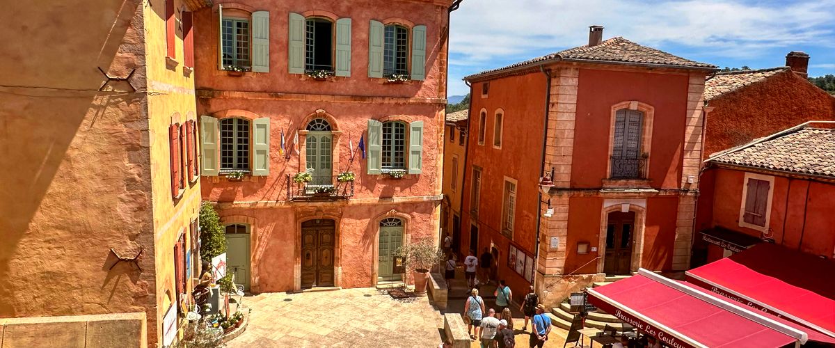 A quiet French street at midday, shutters drawn against the sun